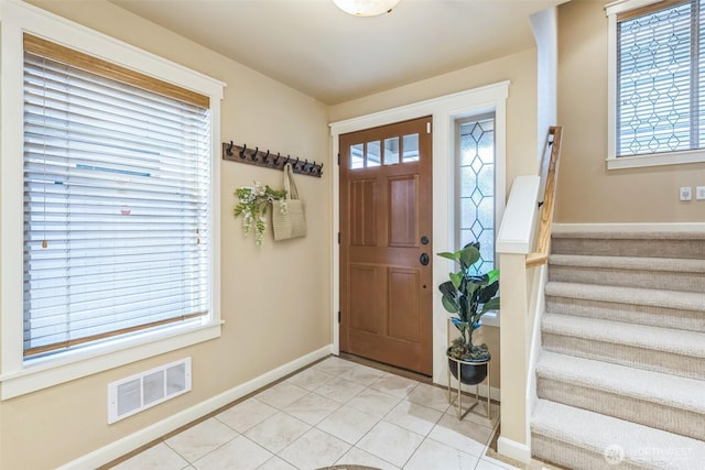entryway featuring visible vents, baseboards, a wealth of natural light, and stairway