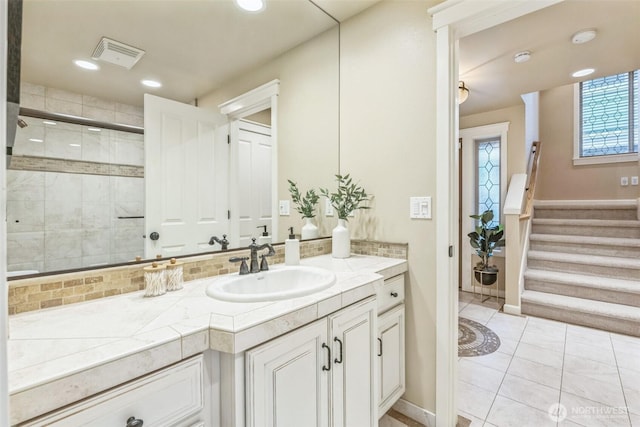 bathroom featuring backsplash, visible vents, a shower stall, and vanity