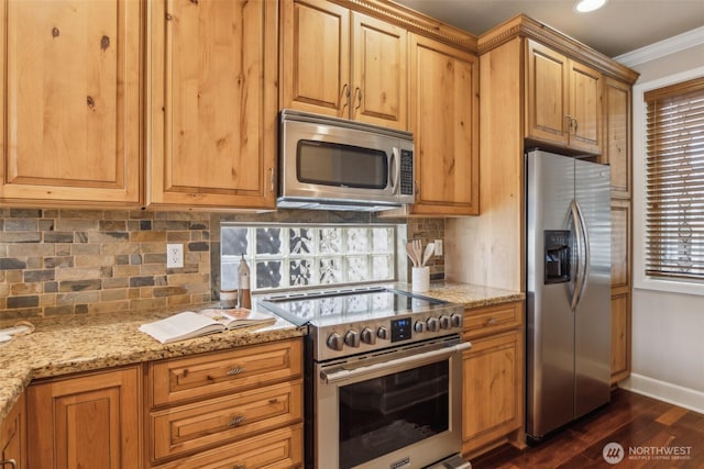 kitchen featuring appliances with stainless steel finishes, baseboards, light stone counters, dark wood-style floors, and ornamental molding