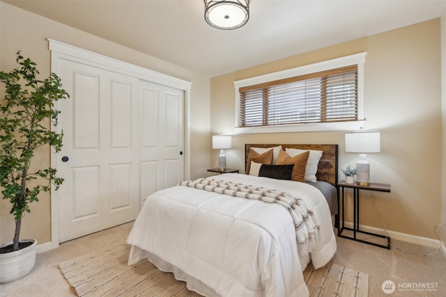 bedroom featuring baseboards, light colored carpet, and a closet