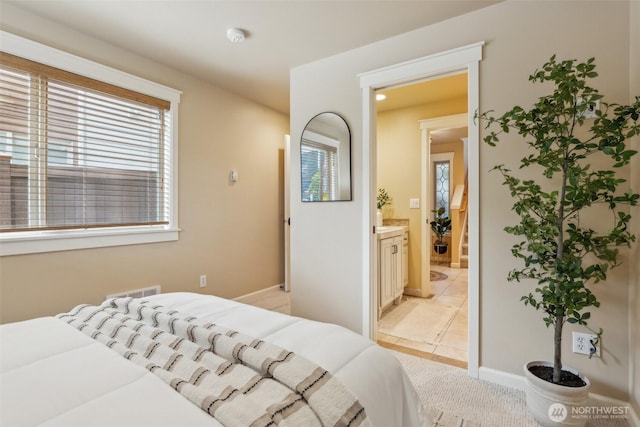 bedroom featuring baseboards, connected bathroom, and multiple windows