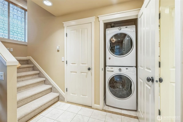 washroom featuring laundry area, stacked washer and dryer, baseboards, recessed lighting, and light tile patterned floors