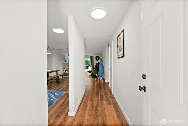 corridor featuring baseboards and wood finished floors