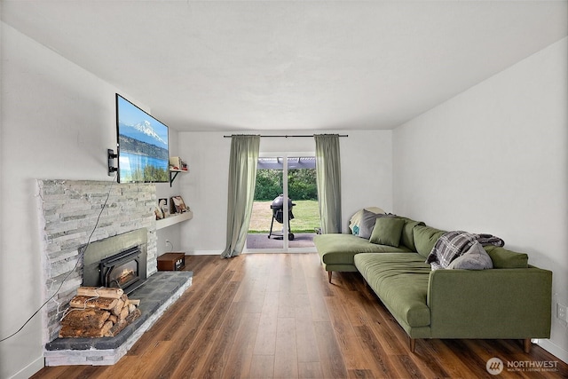 living area featuring baseboards, wood finished floors, and a fireplace