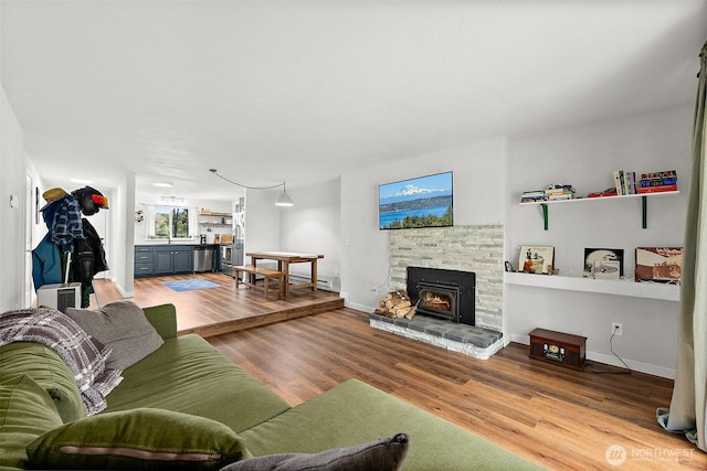 living area with baseboards and wood finished floors