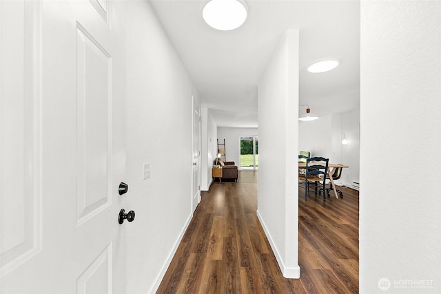 hall featuring baseboards and dark wood finished floors