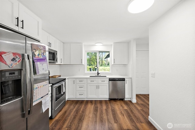 kitchen featuring dark wood-style flooring, a sink, light countertops, stainless steel appliances, and white cabinetry