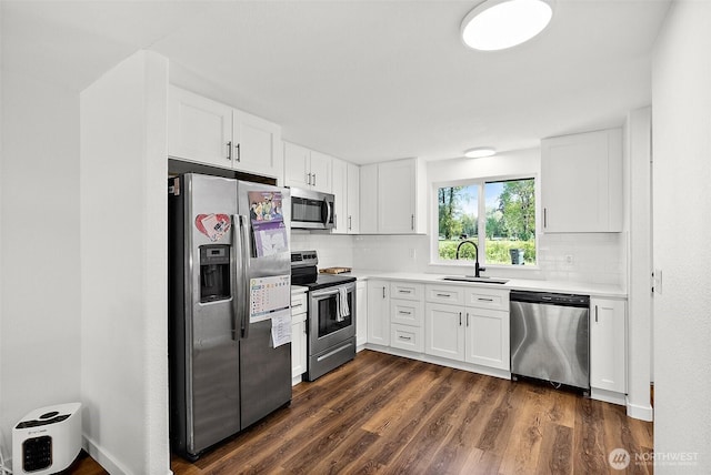 kitchen featuring backsplash, white cabinetry, appliances with stainless steel finishes, and a sink