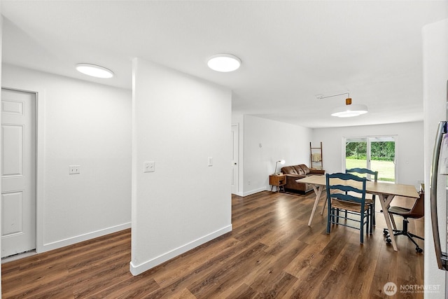 dining room featuring baseboards and dark wood-style floors