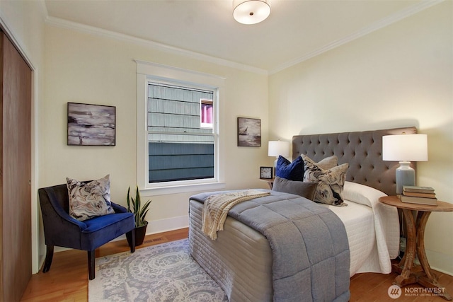 bedroom featuring crown molding, baseboards, a closet, and wood finished floors