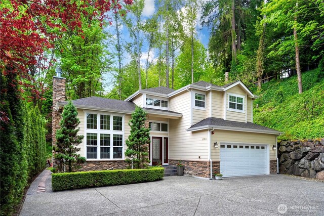 1823 Richards Rd, Bellevue, WA 98005 - tri-level home featuring a chimney, a garage, stone siding, and concrete driveway