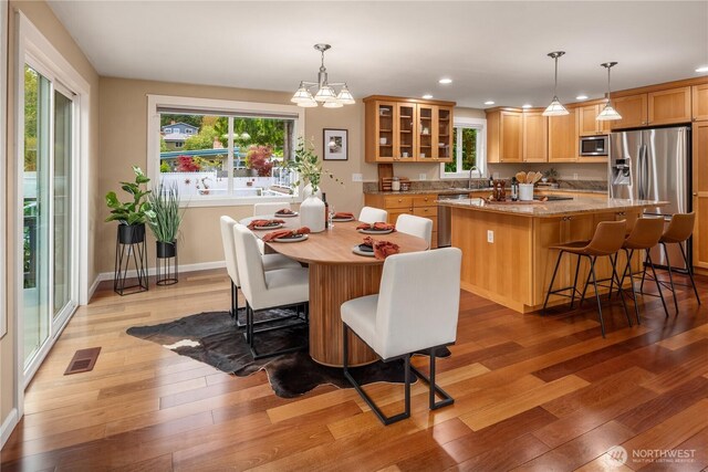 dining area with recessed lighting, visible vents, a wealth of natural light, and light wood finished floors