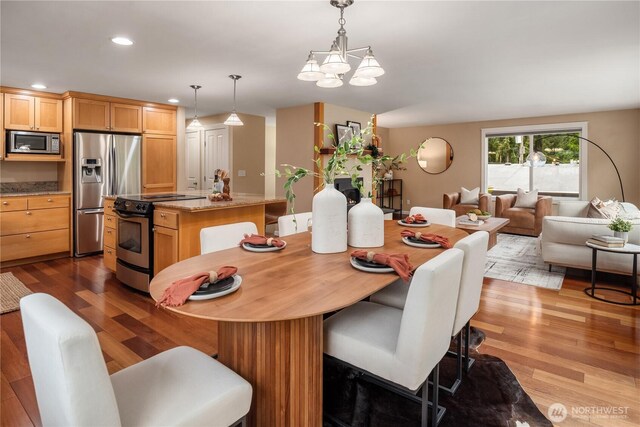 dining area featuring an inviting chandelier, recessed lighting, and wood finished floors