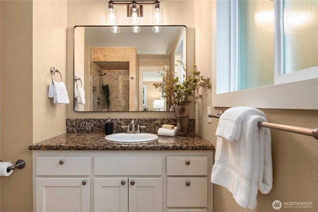 full bath with vanity and tiled shower