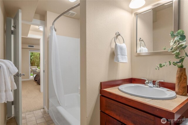 bathroom featuring vanity, shower / bathtub combination with curtain, and visible vents