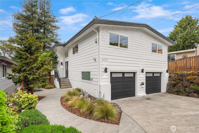 view of side of property featuring an attached garage and driveway