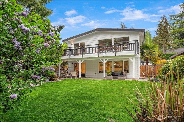 back of property with fence, an outdoor hangout area, a balcony, a lawn, and a patio