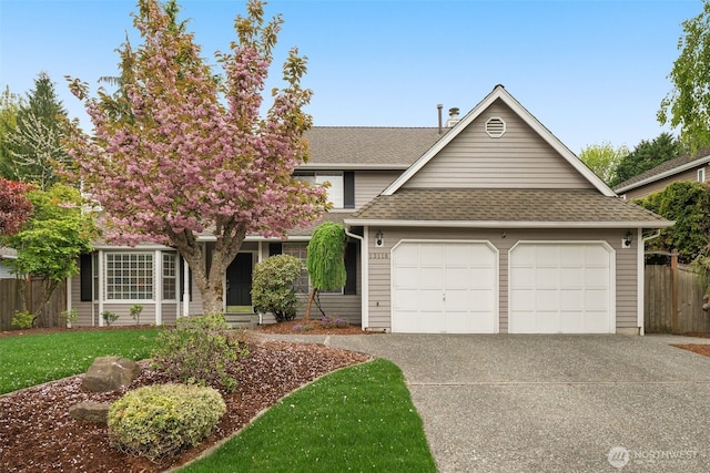 view of front of house featuring fence, a front lawn, concrete driveway, an attached garage, and a shingled roof