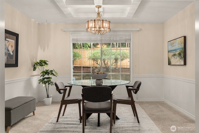 carpeted dining space with a chandelier and coffered ceiling