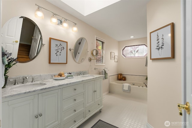 full bath featuring a sink, a skylight, a garden tub, and double vanity