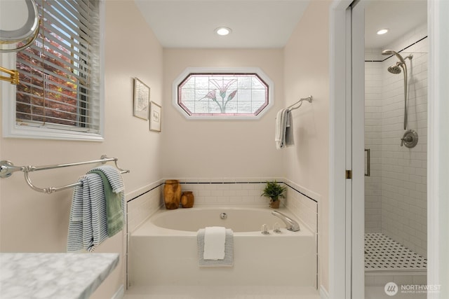 bathroom with recessed lighting, a bath, and a stall shower