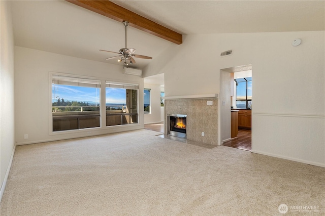 1113 5th Ave S Unit 301, Edmonds, WA 98020 - unfurnished living room with carpet floors, ceiling fan, a wall mounted air conditioner, beamed ceiling, and a fireplace