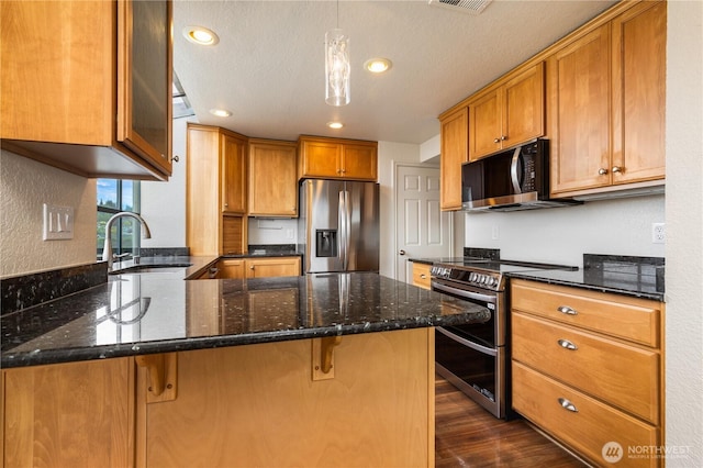 1113 5th Ave S Unit 301, Edmonds, WA 98020 - kitchen with stainless steel appliances, a peninsula, a sink, brown cabinetry, and recessed lighting