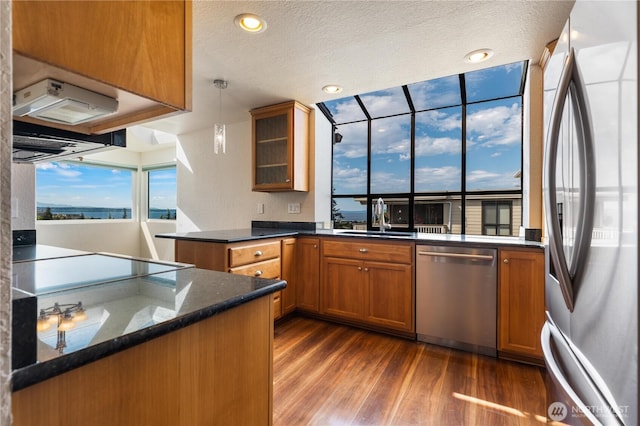 1113 5th Ave S Unit 301, Edmonds, WA 98020 - kitchen with appliances with stainless steel finishes, a sink, brown cabinetry, dark wood-type flooring, and glass insert cabinets