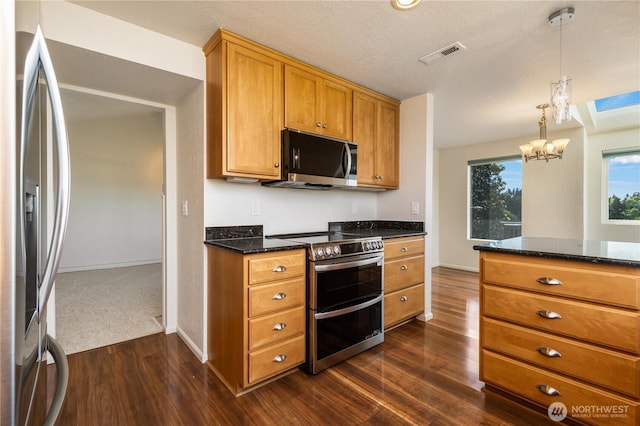 1113 5th Ave S Unit 301, Edmonds, WA 98020 - kitchen featuring stainless steel appliances, dark wood-style floors, a chandelier, brown cabinets, and dark stone countertops