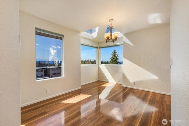 1113 5th Ave S Unit 301, Edmonds, WA 98020 - unfurnished dining area with baseboards, a chandelier, wood finished floors, and a textured wall