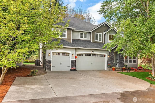 craftsman inspired home featuring driveway, roof with shingles, a garage, cooling unit, and stone siding