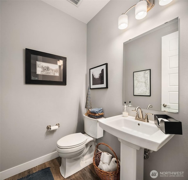 bathroom featuring toilet, baseboards, and wood finished floors