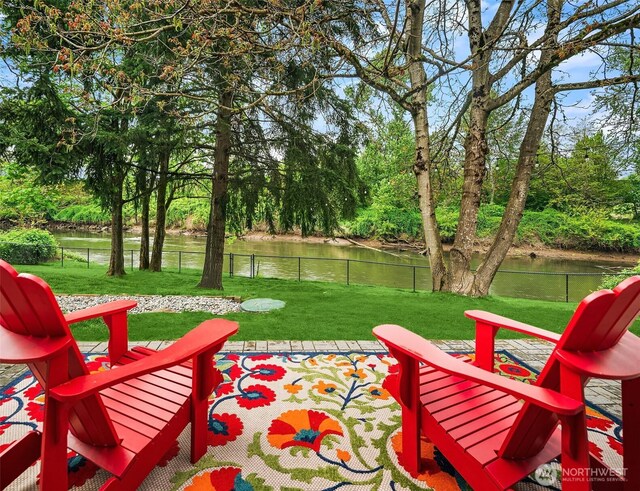 view of patio / terrace with fence and a water view