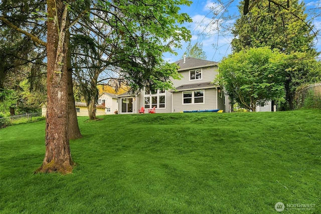 back of house featuring a yard and fence