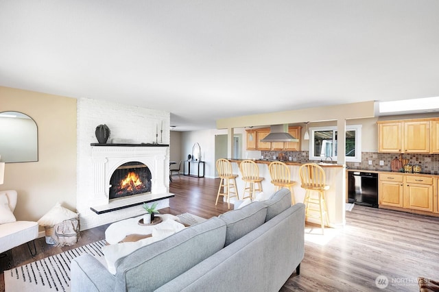 living area featuring light wood finished floors and a large fireplace