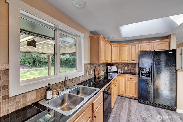 kitchen with black appliances, a sink, plenty of natural light, tile counters, and recessed lighting