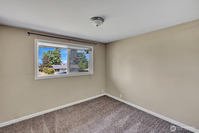 carpeted empty room featuring baseboards