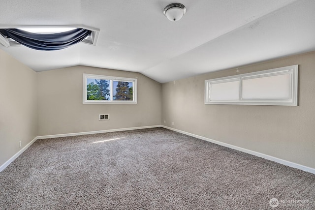 bonus room with vaulted ceiling, carpet floors, and baseboards