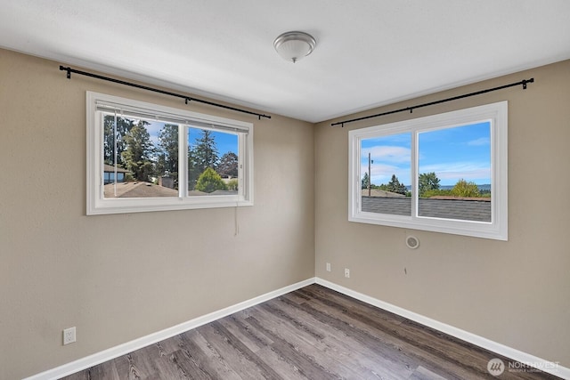 empty room with wood finished floors and baseboards