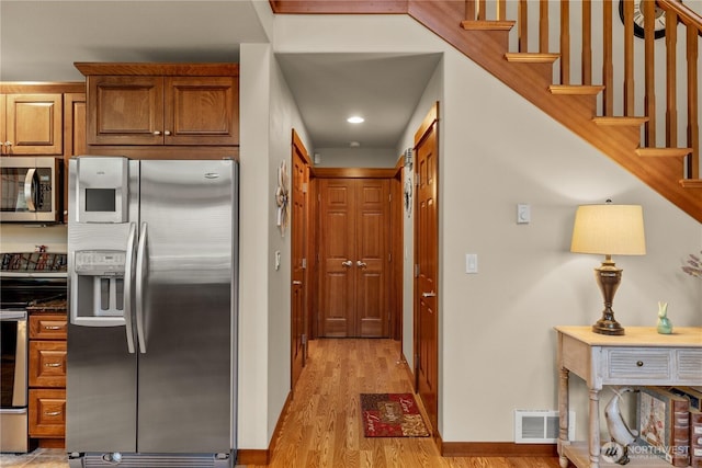 81 N Fawn Dr, Hoodsport, WA 98548 - kitchen featuring brown cabinets, appliances with stainless steel finishes, light wood finished floors, baseboards, and visible vents