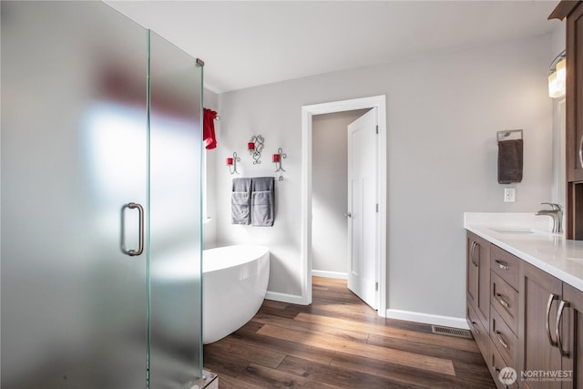 11234 SE 299th Pl, Auburn, WA 98092 - bathroom with wood finished floors, a stall shower, a freestanding bath, baseboards, and vanity