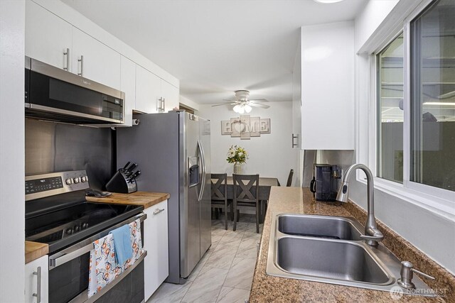 30573 5th Ave SW, Federal Way, WA 98023 - kitchen with a sink, stainless steel appliances, white cabinetry, ceiling fan, and marble finish floor