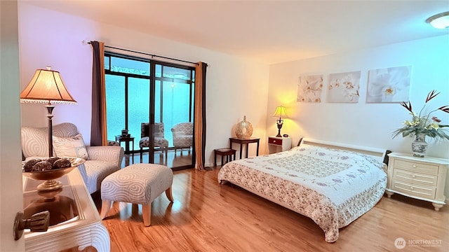 bedroom with wood finished floors and access to exterior