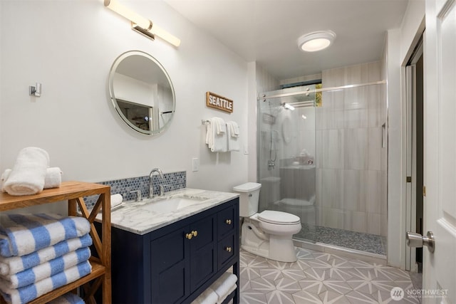 bathroom with toilet, a shower stall, and vanity