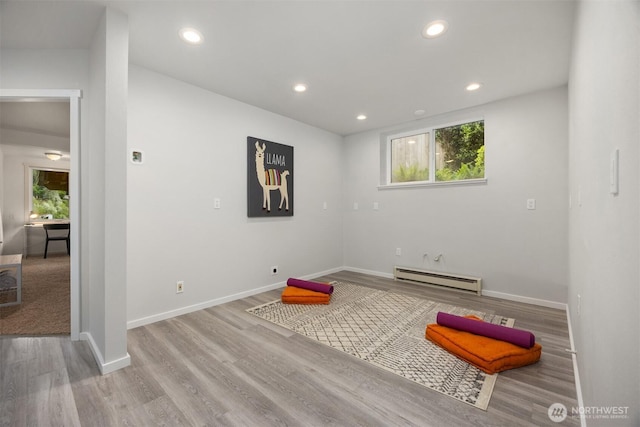 workout area with baseboards, baseboard heating, recessed lighting, and wood finished floors