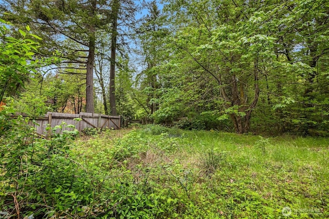 view of yard with fence and a forest view