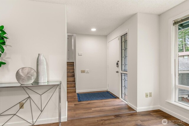 foyer with baseboards, recessed lighting, a textured ceiling, and wood finished floors