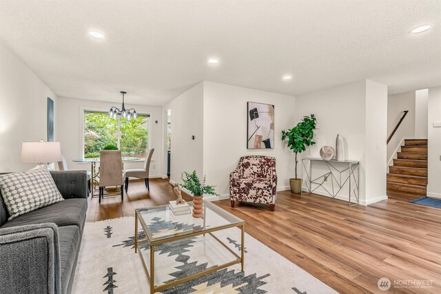 living area featuring recessed lighting, baseboards, wood finished floors, and stairway
