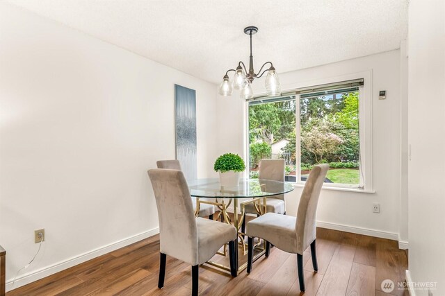 dining room with baseboards, wood finished floors, and a chandelier