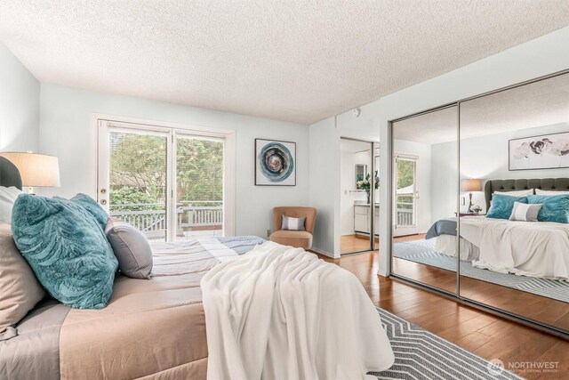 bedroom with access to outside, wood-type flooring, and a textured ceiling